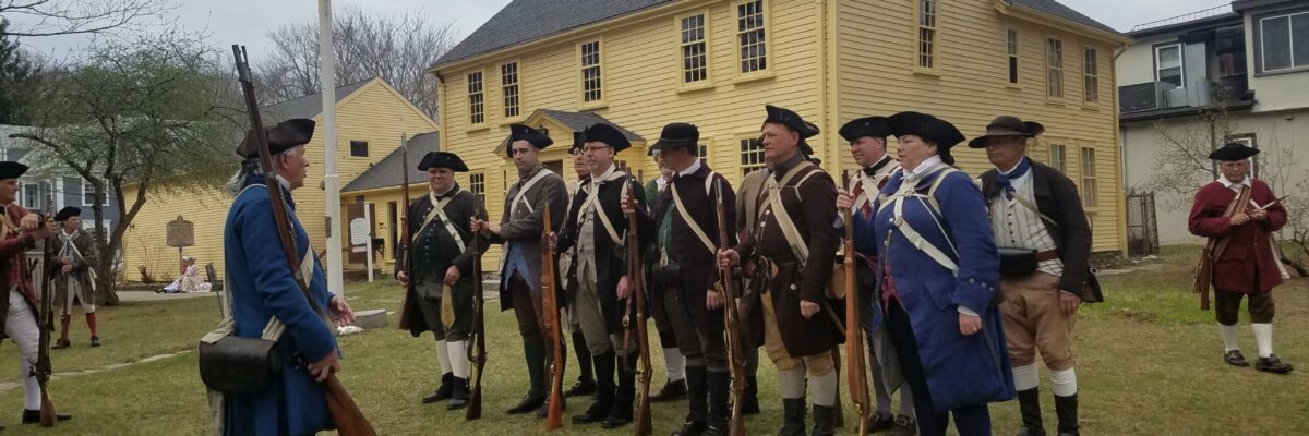 Minutemen reenactors standing in front of Jason Russell House